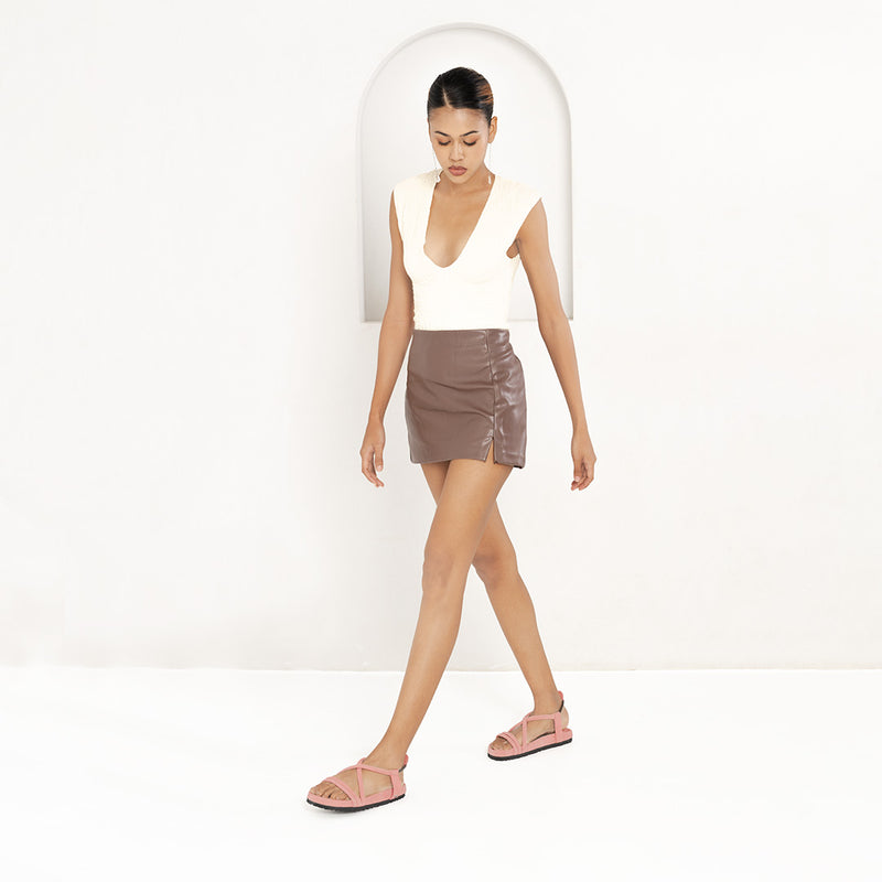 Woman wearing a white top and brown skirt on a white background